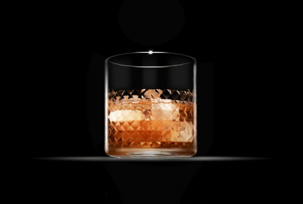Whisky glass against a dark background, illustrative image.